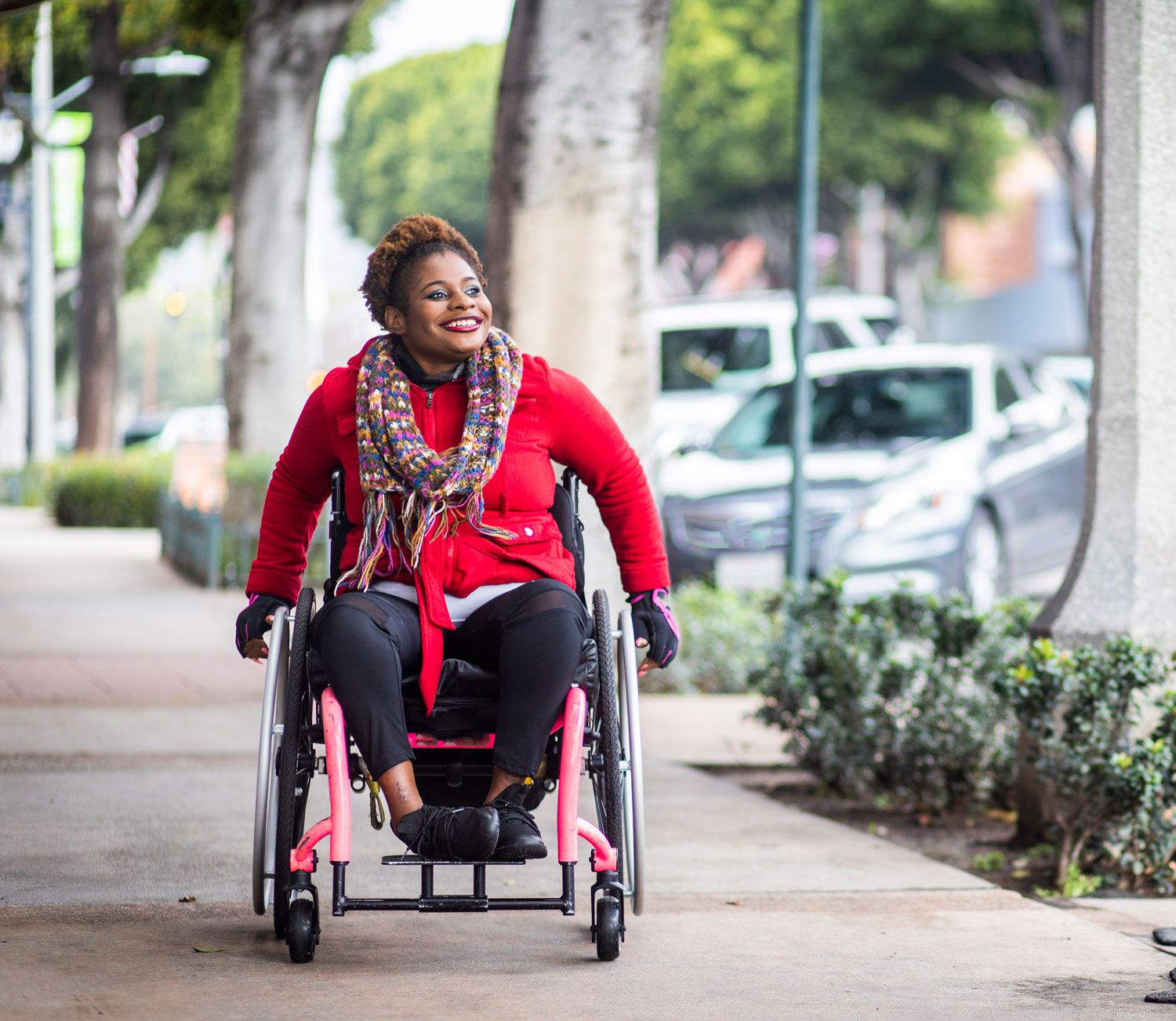 Woman going down sidewalk in a wheelchair